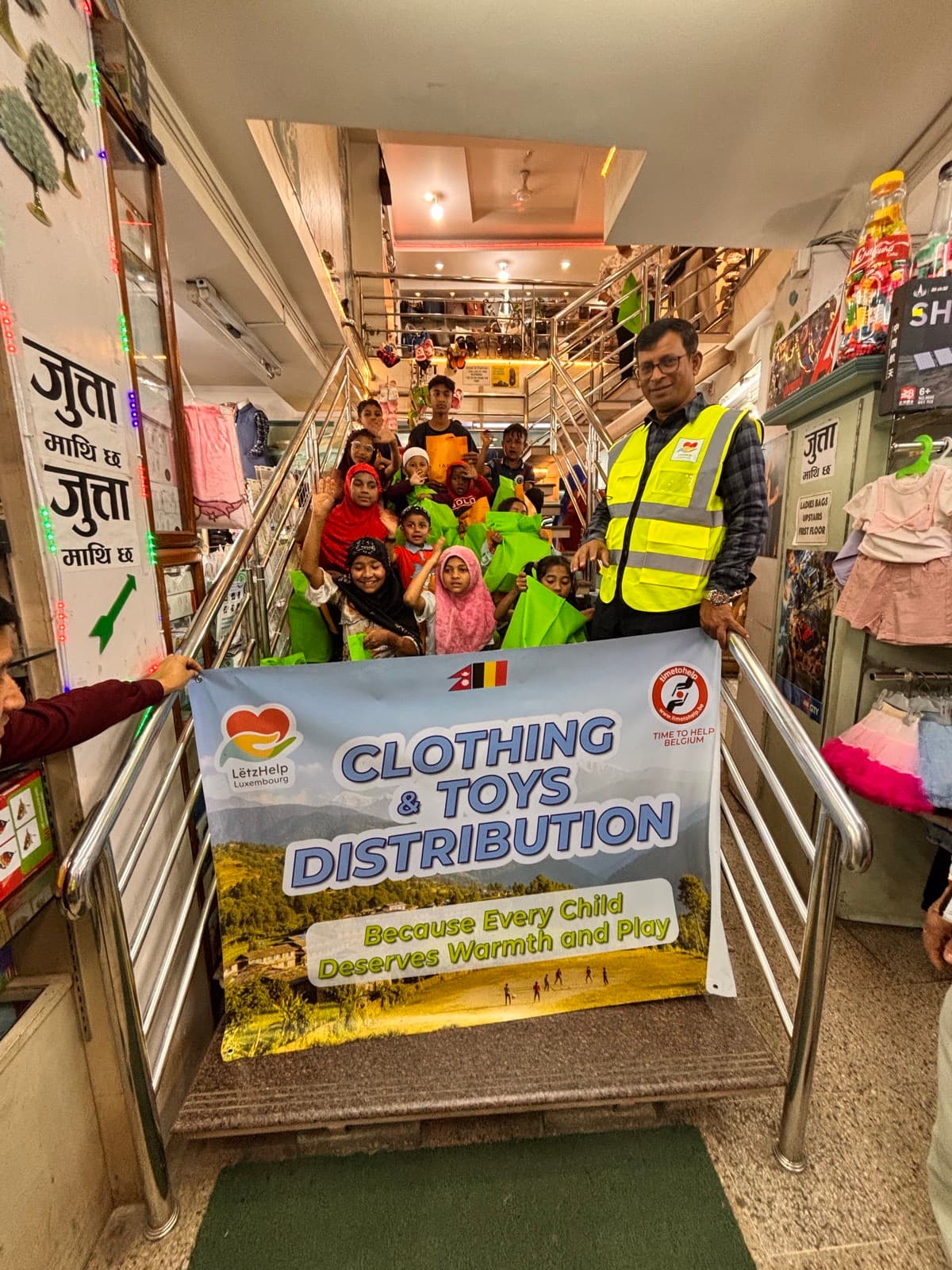 Volunteers holding a Clothing & Toys Distribution banner