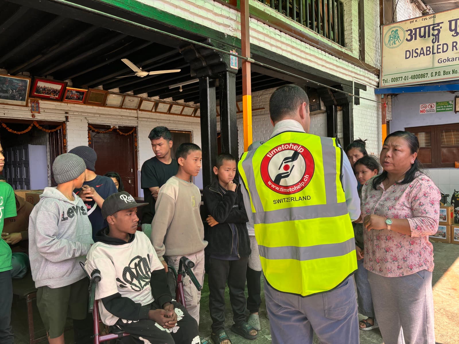 Young people and a staff member listening to a volunteer