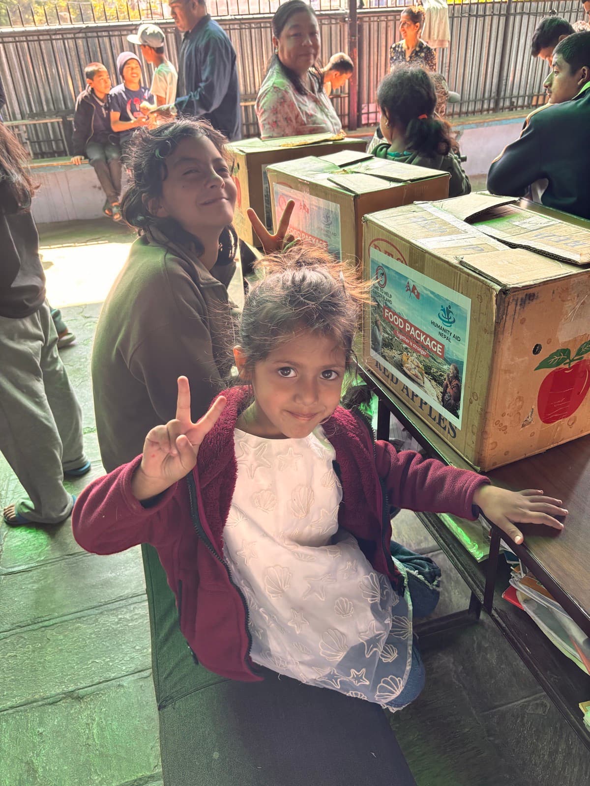 A smiling girl next to boxes of food packages