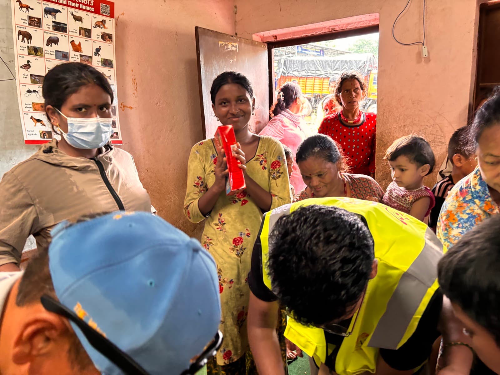 A volunteer handing out relief items to women in a flood-affected community