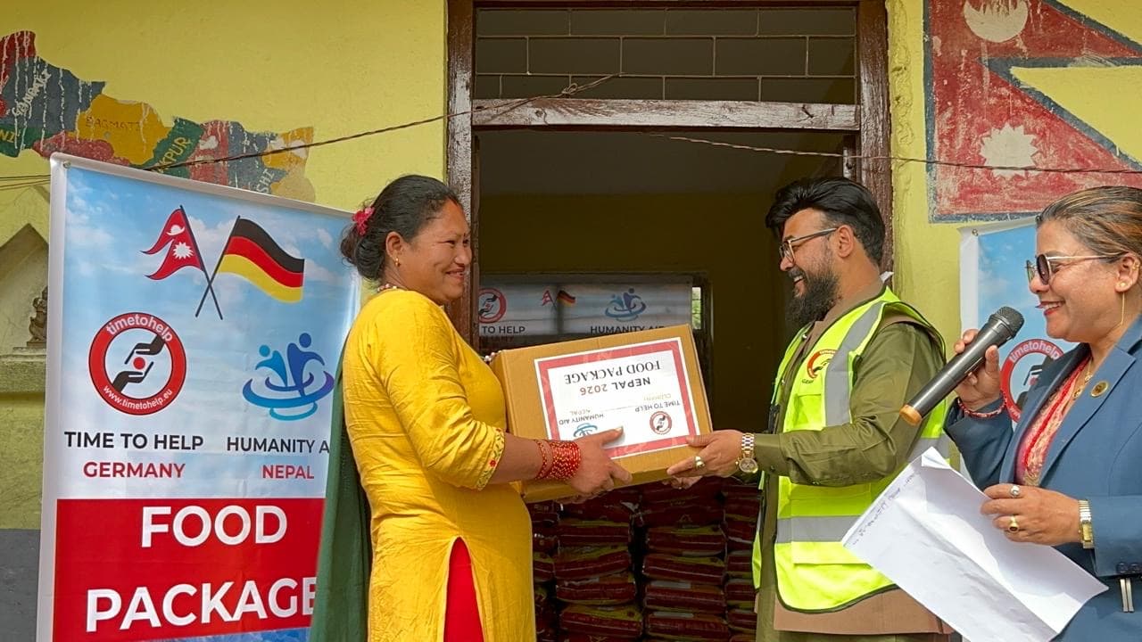 A woman receiving a Nepal 2026 food package box at a distribution point