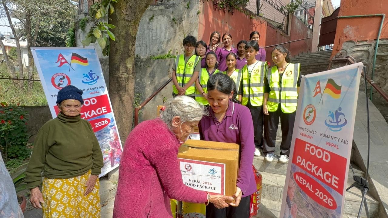 An older woman receiving a food package from a student volunteer