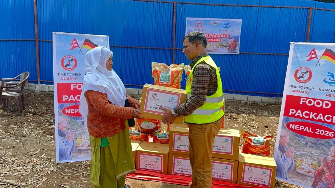 A volunteer handing a food package to a woman at a children's home distribution