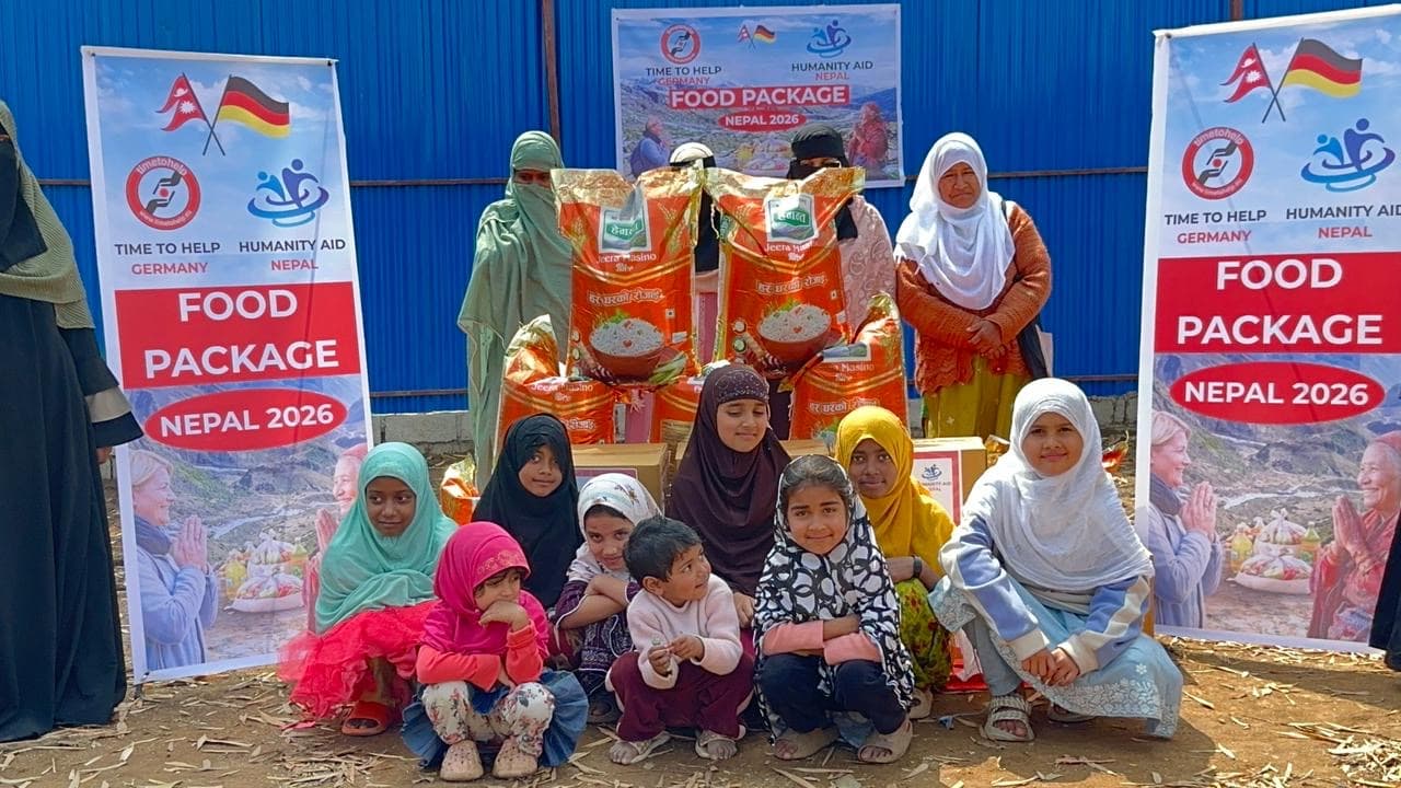 Girls from a children's home sitting in front of rice bags and food packages