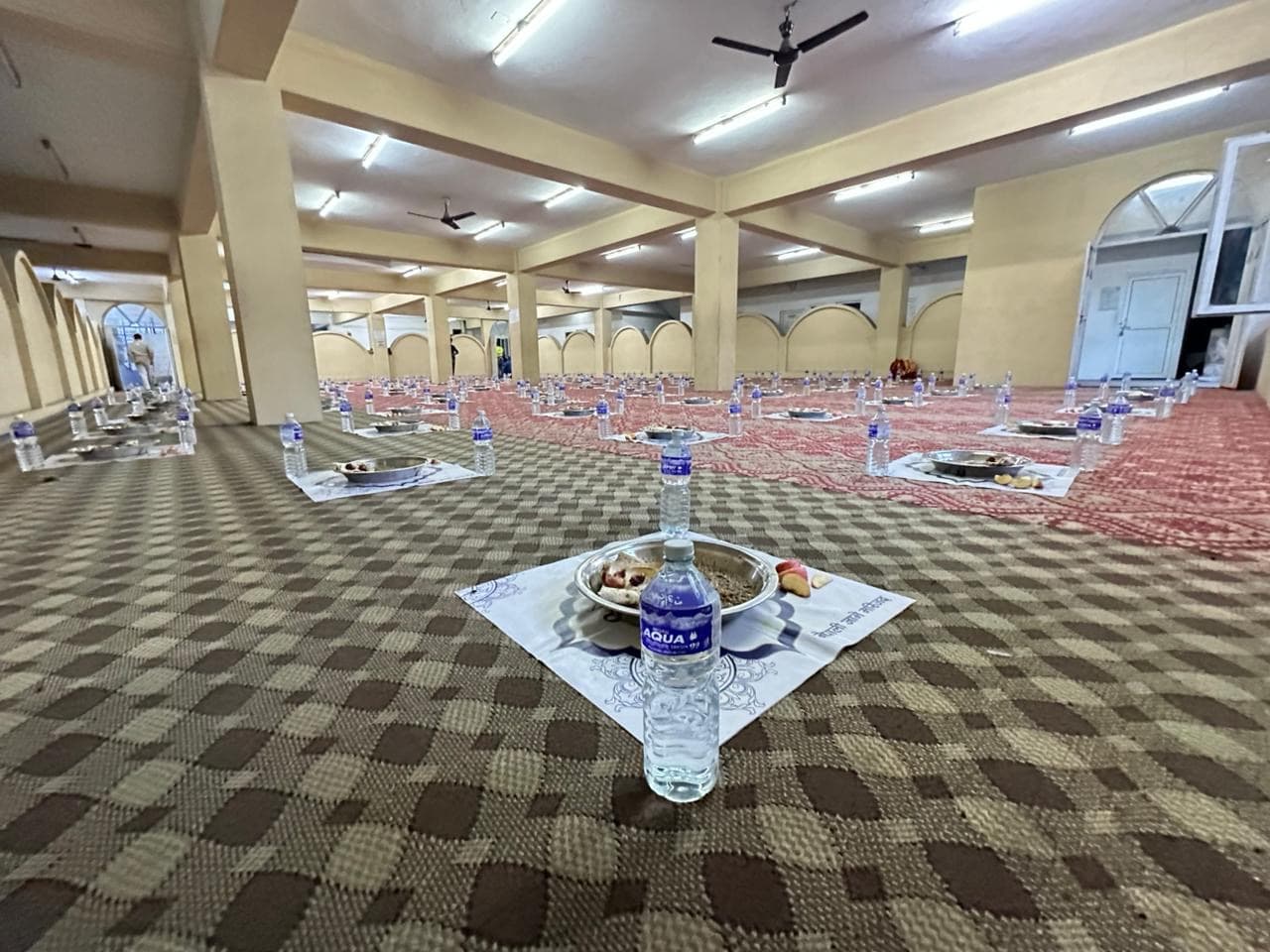 Iftar plates and water bottles laid out in rows before the meal